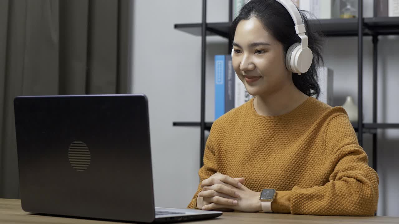 年轻女教师通过笔记本电脑上的在线视频会议向学生讲授在线教育。视频素材