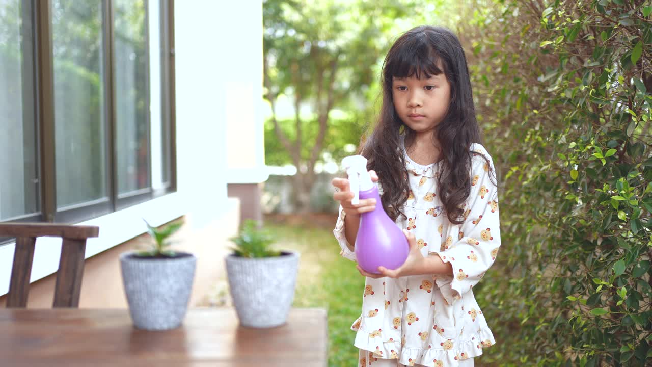 小女孩在早上给一株小植物浇水视频素材