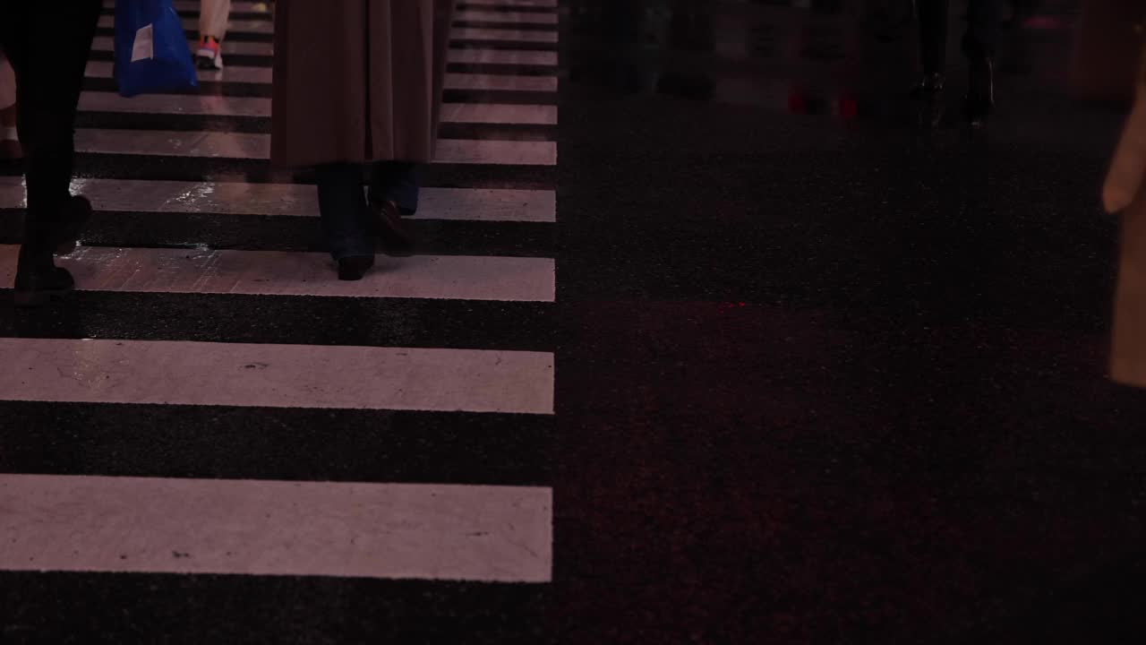 涉谷十字路口的一个雨天，高速拍摄行走的人的身体部位视频素材