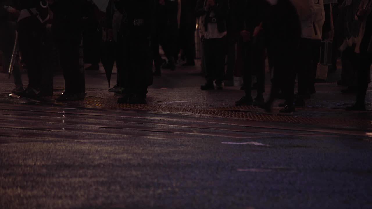 涉谷十字路口的一个雨天，高速拍摄行走的人的身体部位视频素材