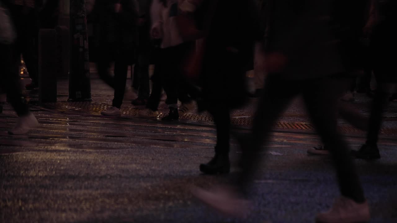 涉谷十字路口的一个雨天，高速拍摄行走的人的身体部位视频素材