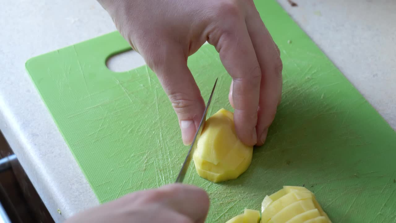 在厨房切土豆的特写慢动作视频素材