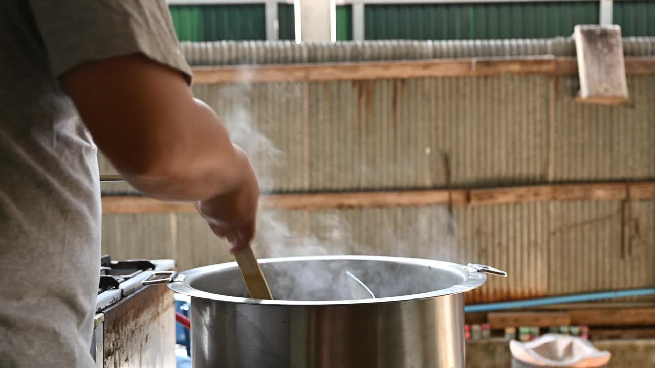 厨师用面条滤网将生牛肉放入面条锅中汆烫视频素材