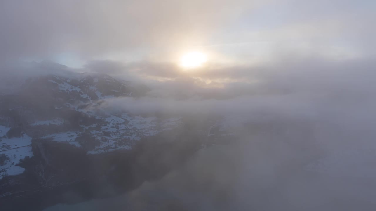 一段时间的朦胧日落在雪山覆盖着云。阳光在山的上方。Walensee。格拉鲁斯州菲兹巴赫卡伦泽伯格的鸟瞰图视频素材