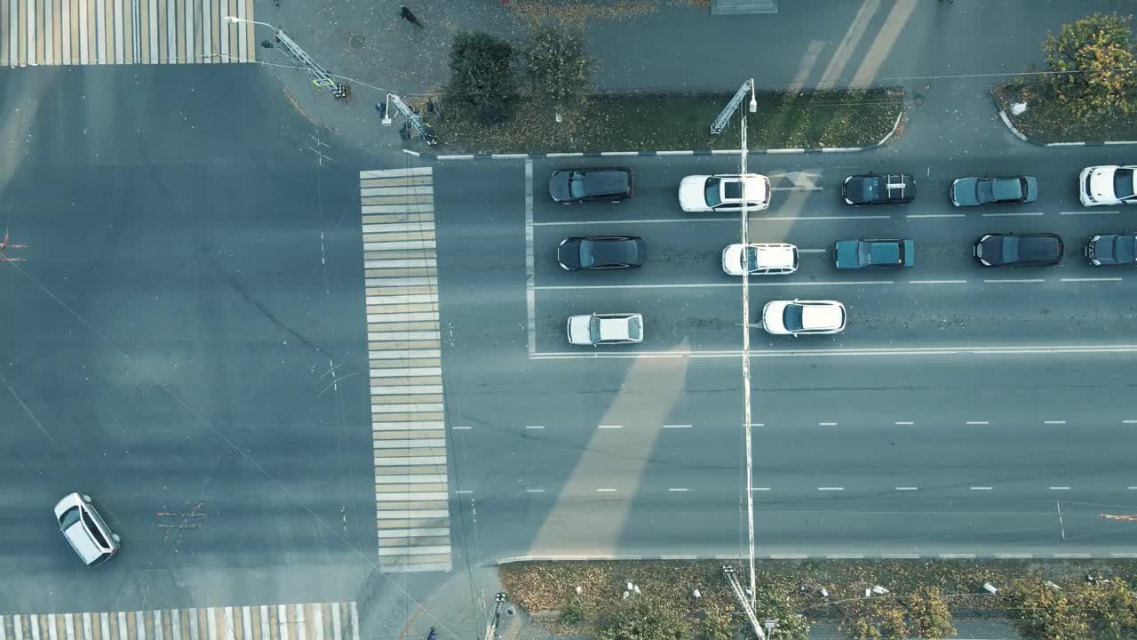 早晨宽阔的十字路口，车辆停在红绿灯前。视频素材