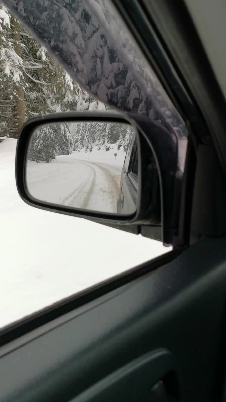 汽车观点。2019冠状病毒病(COVID-19)大流行期间，在大雪中行驶在高速公路上上班。看着侧视镜。生活忙碌，交通慢了下来。视频素材