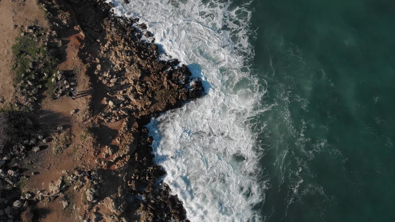 鸟瞰图海浪打破岩石在蓝色的海洋。海浪无人机4k拍摄。从上面鸟瞰海浪撞击空石头的景象视频下载