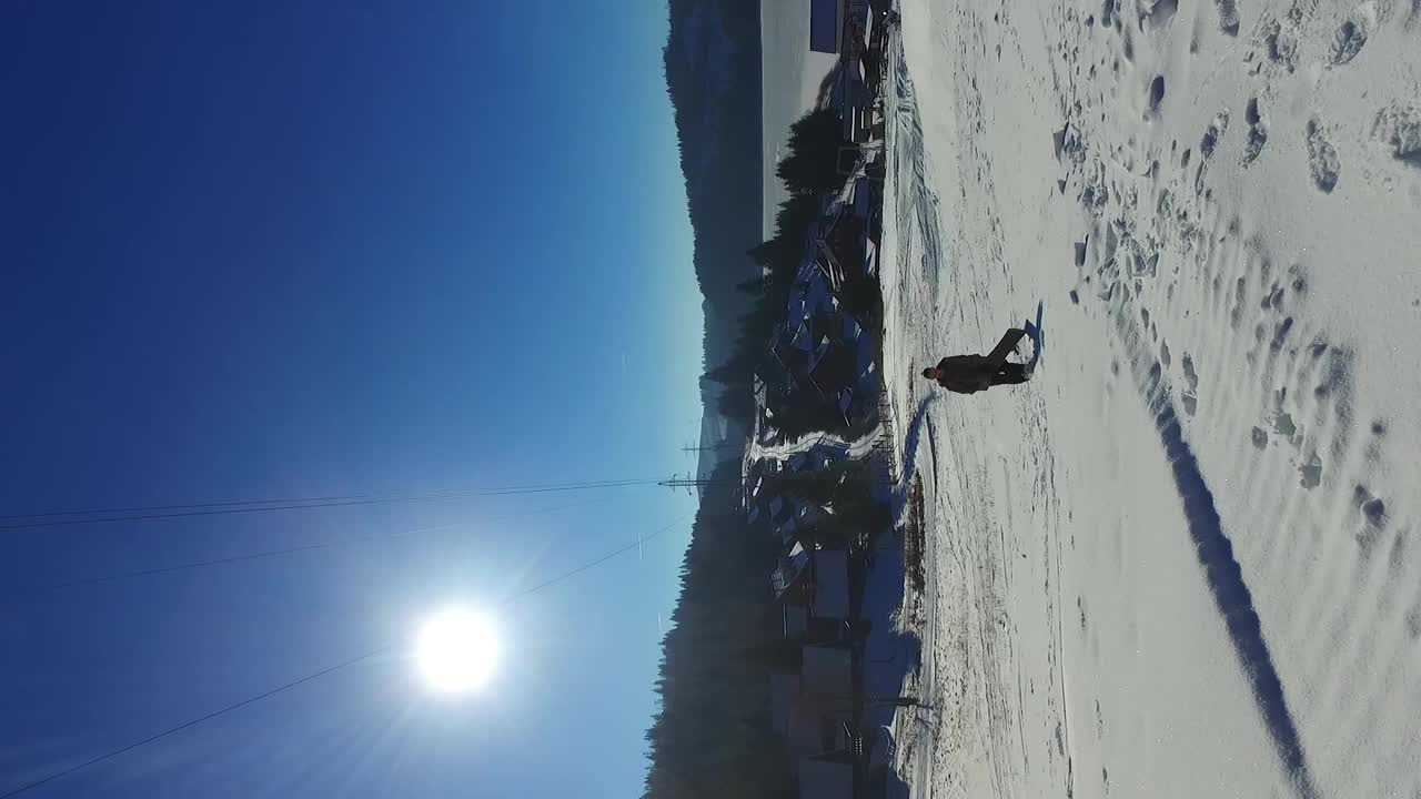 垂直镜头的滑雪板行走与滑雪板上山。视频下载