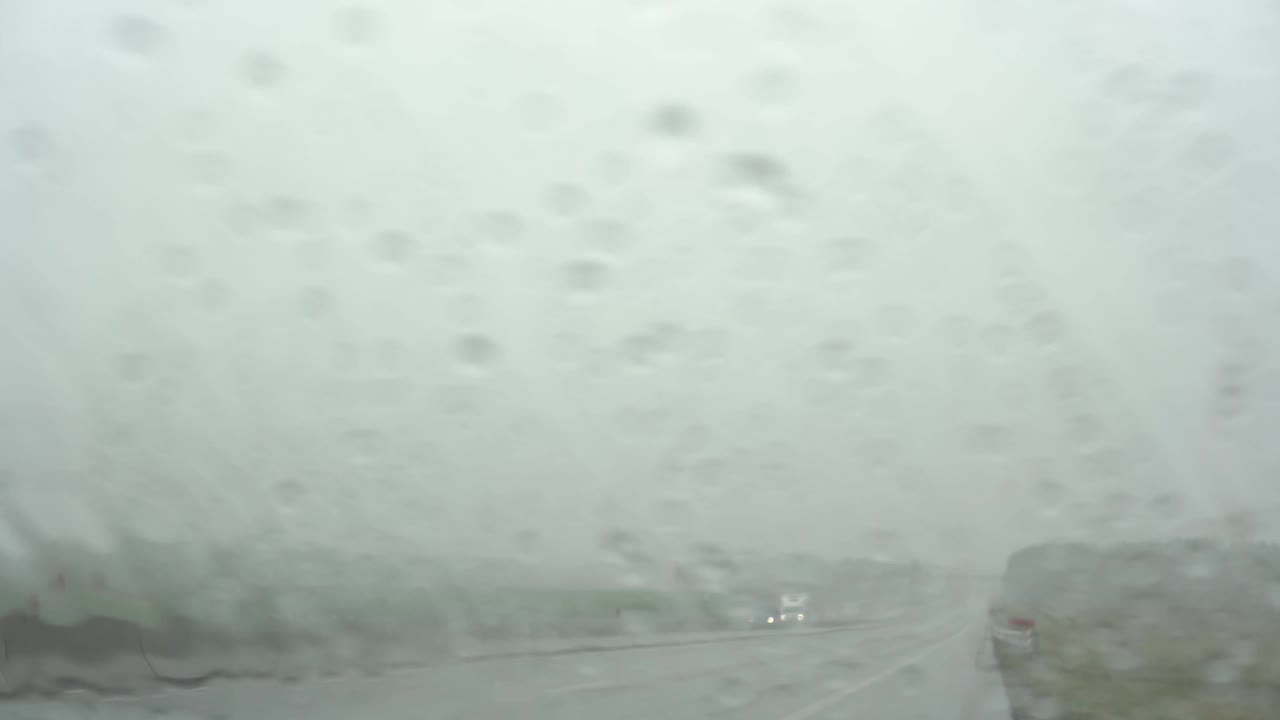 大雨下着，各种汽车在宽阔潮湿的道路上行驶视频素材