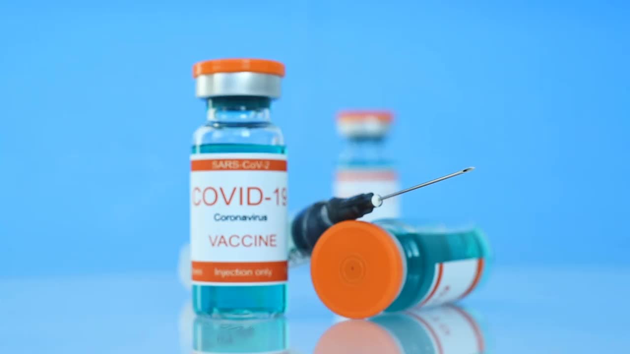 装有Covid-19疫苗和注射器的玻璃瓶。视频素材