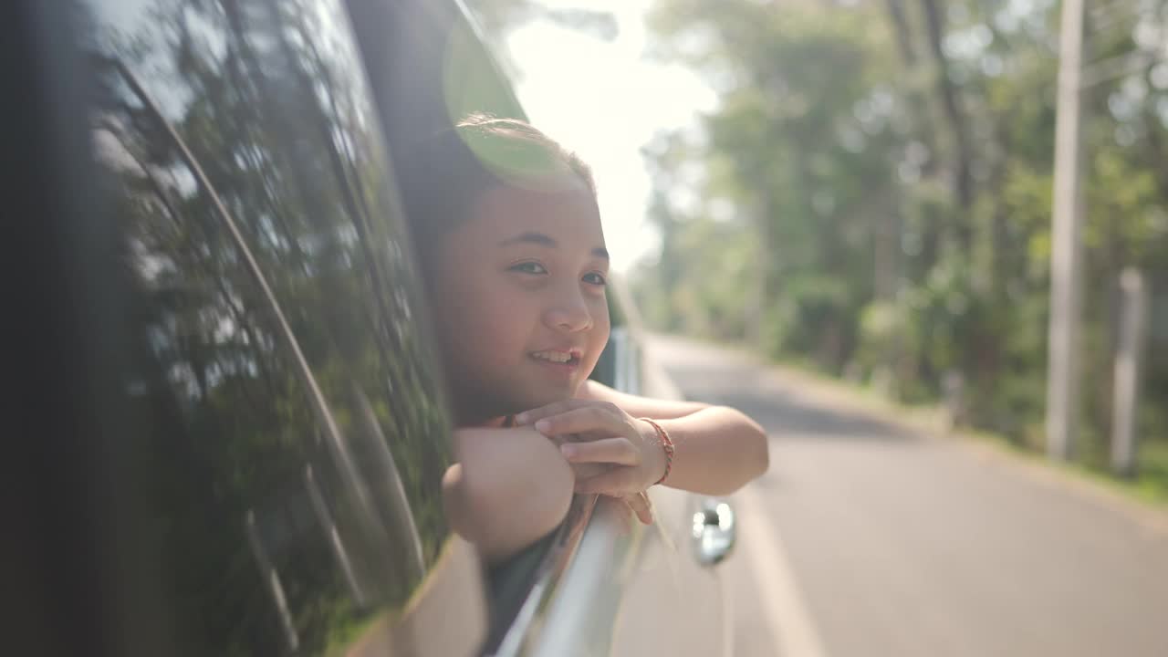 快乐的亚洲小女孩享受和父母在汽车上的公路旅行假期。视频素材