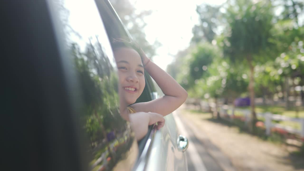 快乐的亚洲小女孩享受和父母在汽车上的公路旅行假期。视频下载