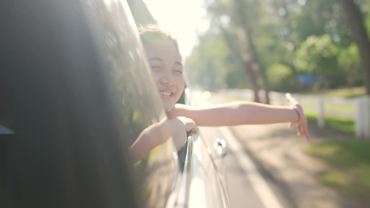 快乐的亚洲小女孩享受和父母在汽车上的公路旅行假期。视频素材