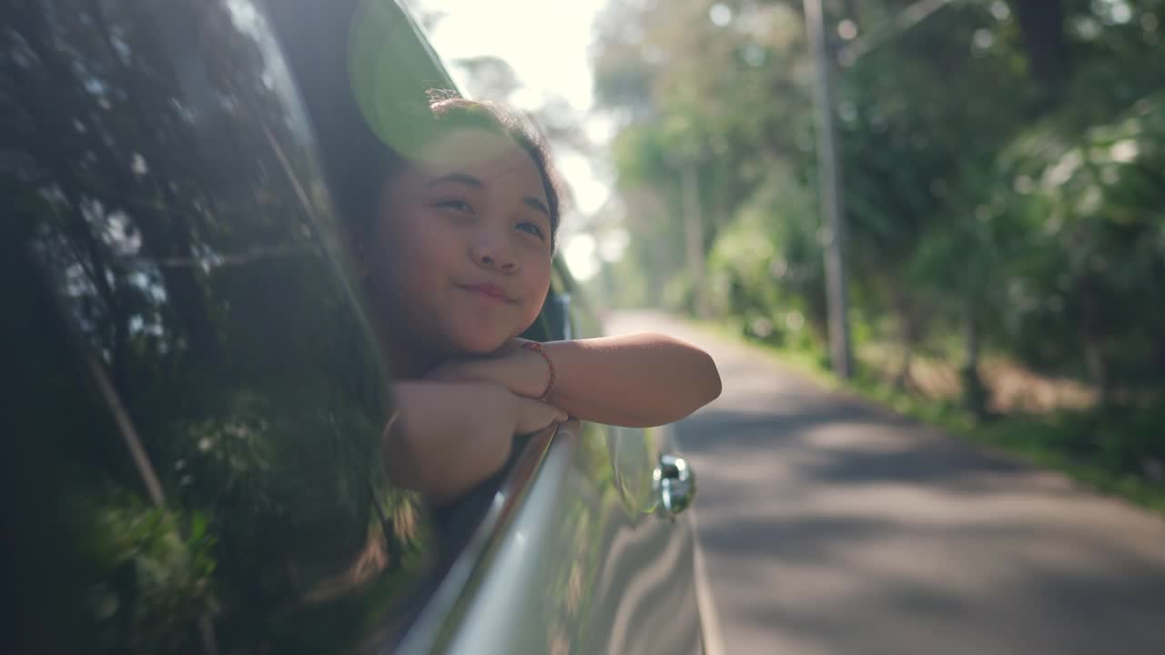 快乐的亚洲小女孩享受和父母在汽车上的公路旅行假期。视频素材