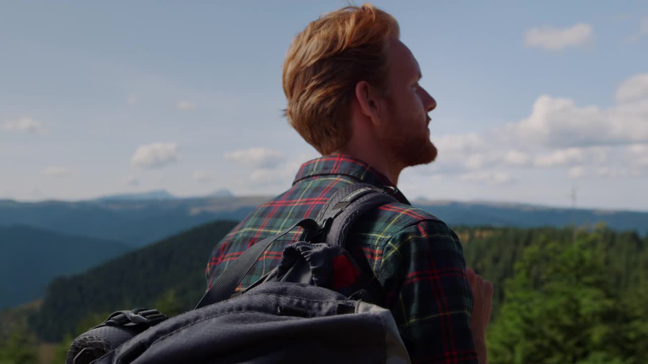 专注的人在山上看风景。男游客背背包视频素材