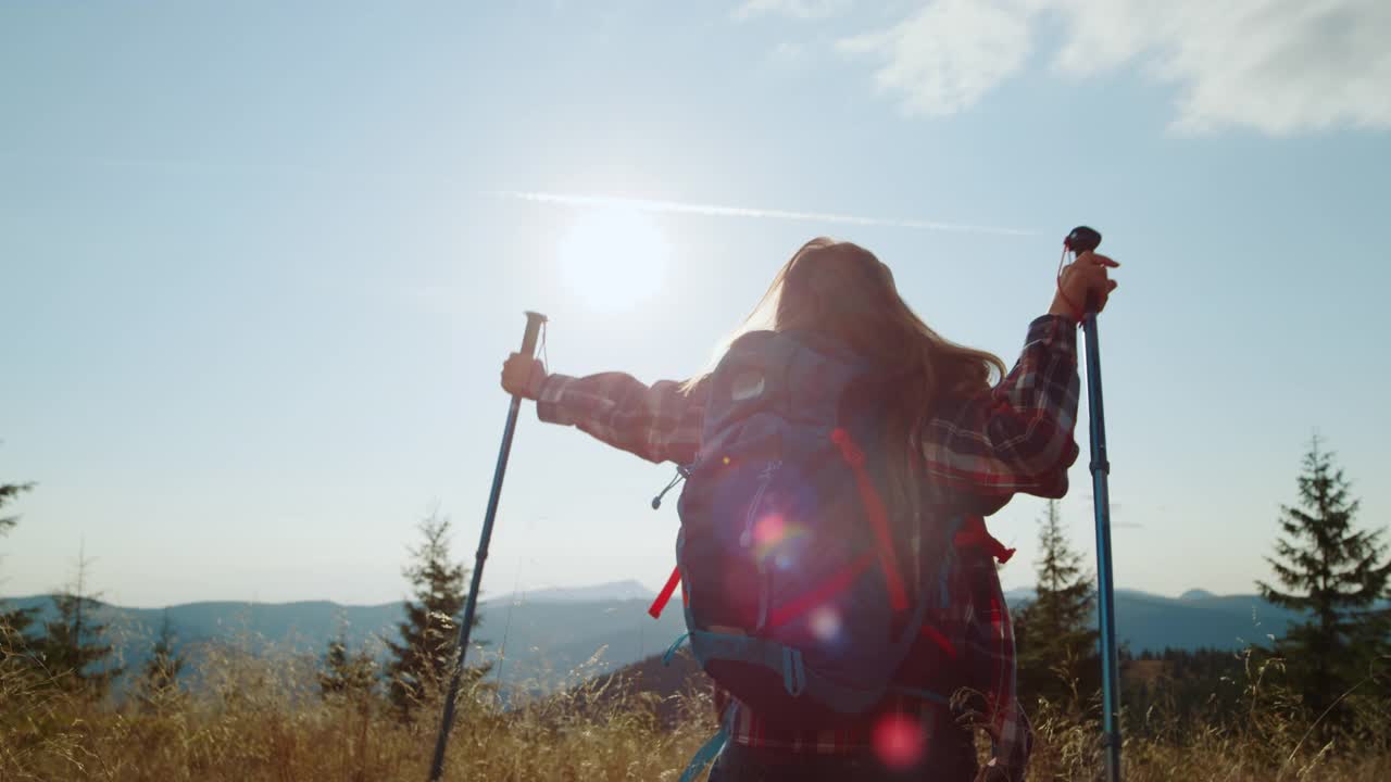 快乐的女人在山上举起双手。女游客庆祝胜利视频素材