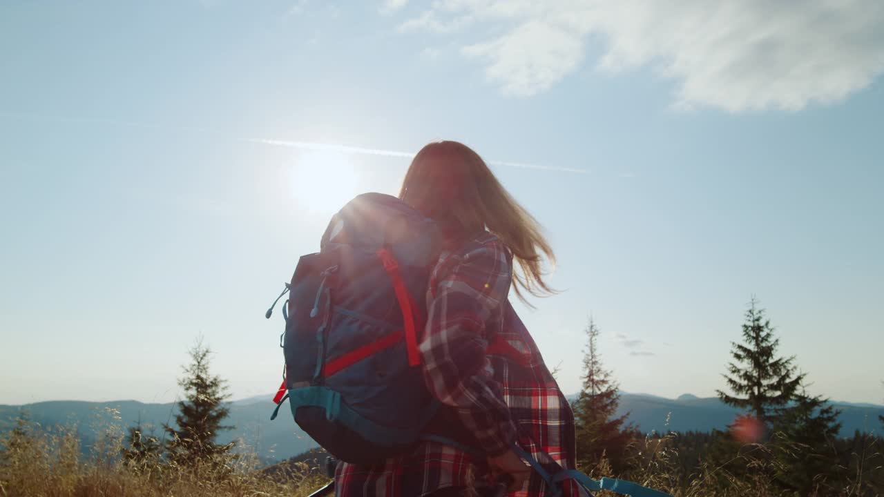 兴奋的女人在登山时举起手。徒步旅行者感到自由视频素材