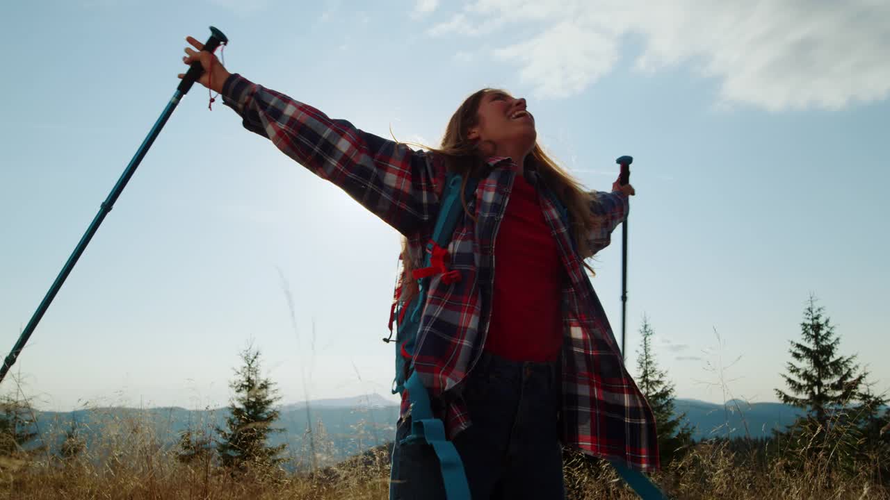 站在山顶的女游客。快乐的女孩举起双手在空中视频素材