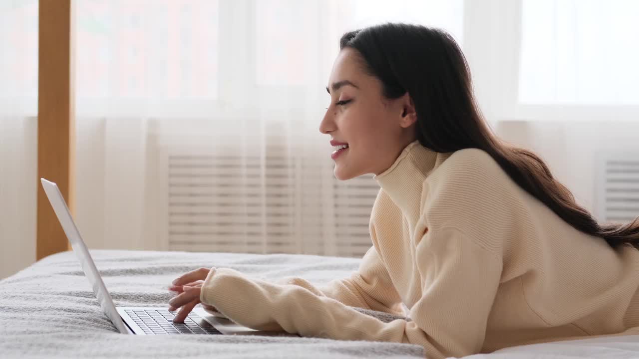 沮丧的女人在床上躺着的时候关闭笔记本电脑视频素材