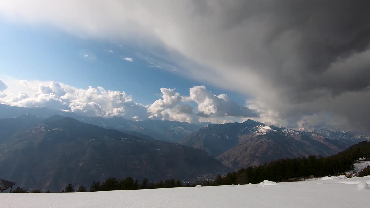 从印度喜马偕尔邦马纳里附近的Bijli Mahadev寺庙看到的被雪覆盖的Kullu山谷山峰上暴风雨云的时间推移视频素材