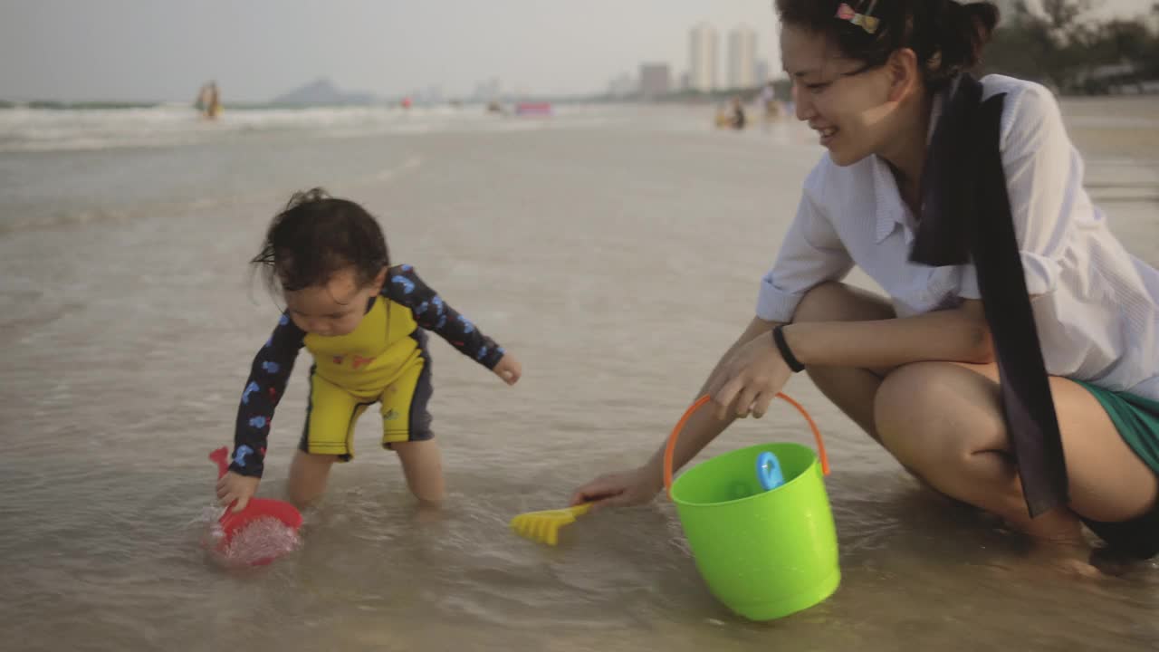 快乐的亚洲家庭一起在海里嬉戏视频素材