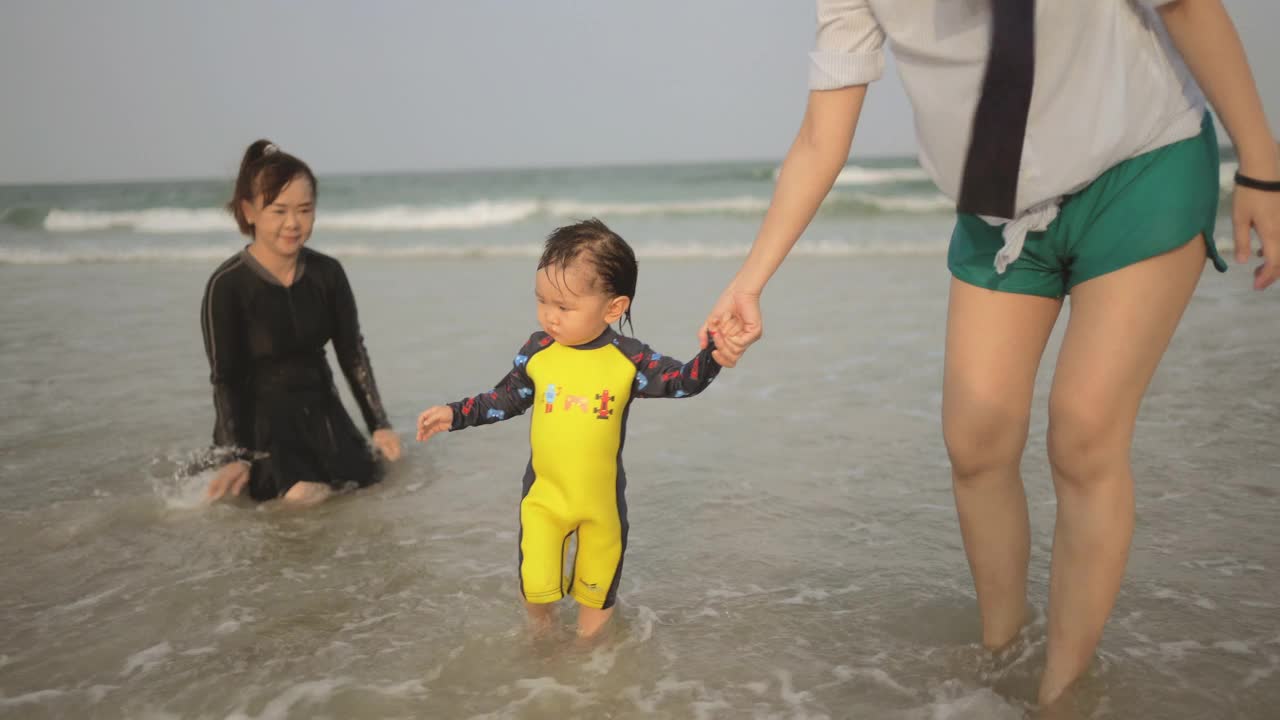 快乐的亚洲家庭一起在海里嬉戏视频素材