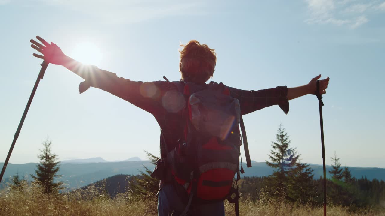 一个站在山顶的人。徒步旅行时男性游客举手视频素材