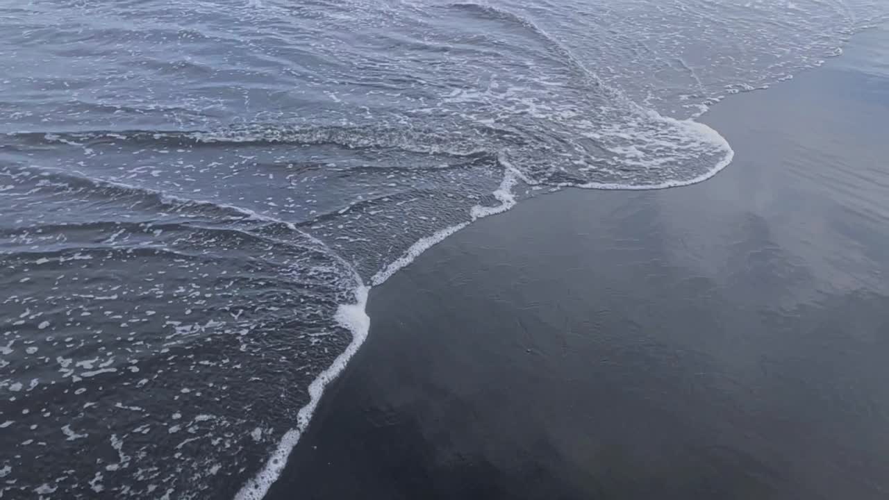 海洋/海岸上的黑砂火山海滩。视频素材