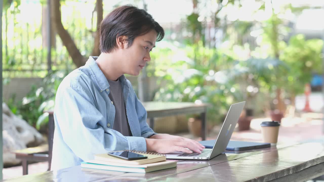 年轻的亚洲人大学学生使用笔记本电脑，同时在校园在线学习，社会距离视频素材