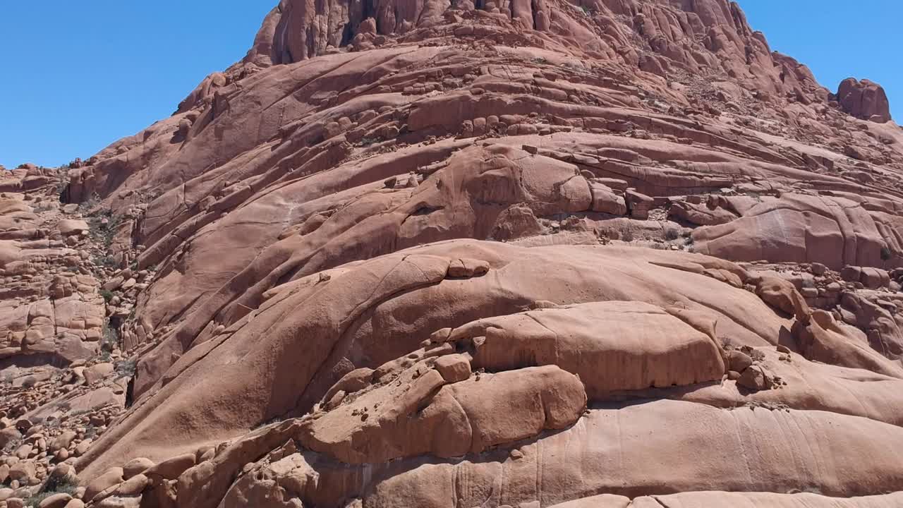 在纳米比亚的斯匹茨科普，从底部到顶部的红色岩石山，有着清澈清澈的蓝色天空视频素材