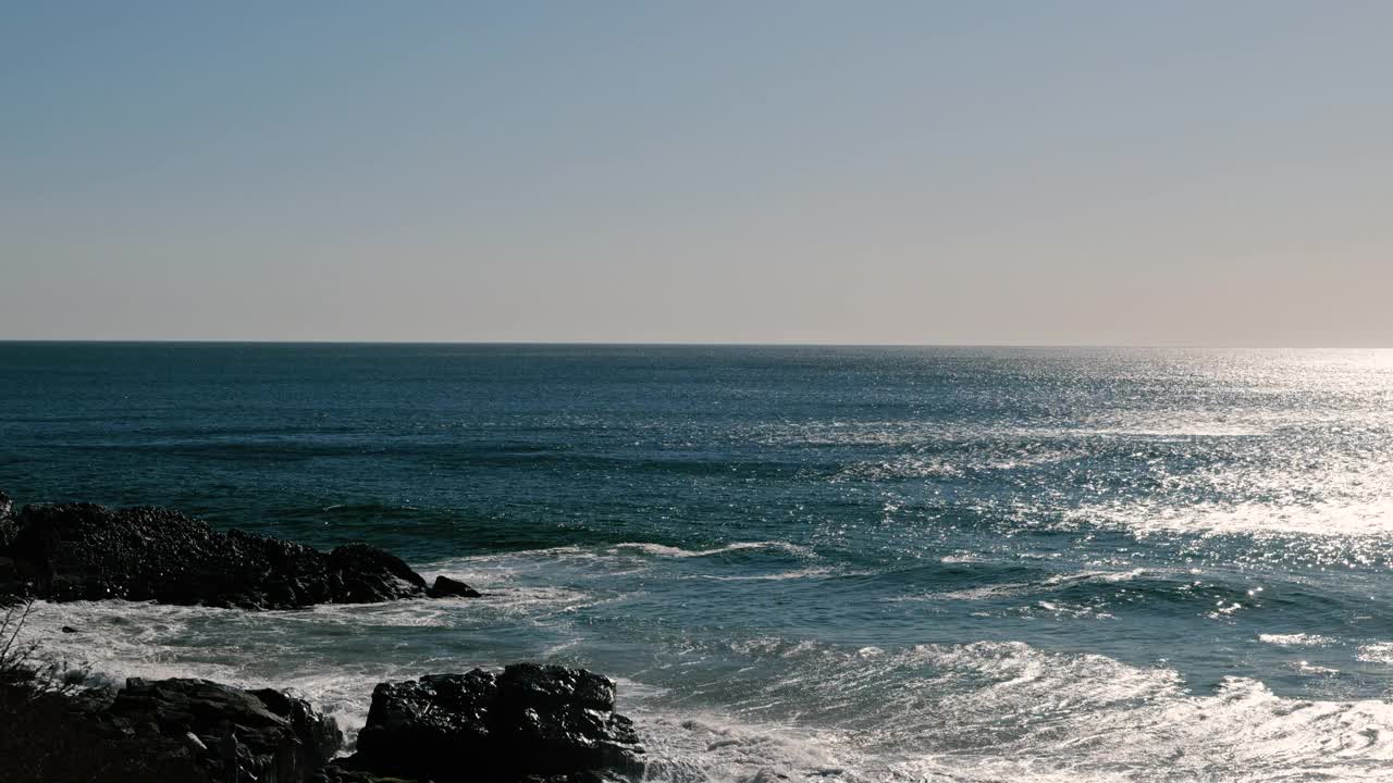 在一个热带度假胜地，海浪冲击着海岸线上的岩石视频素材