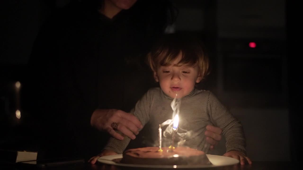 宝贝吹生日蜡烛快乐。庆祝两周年视频素材