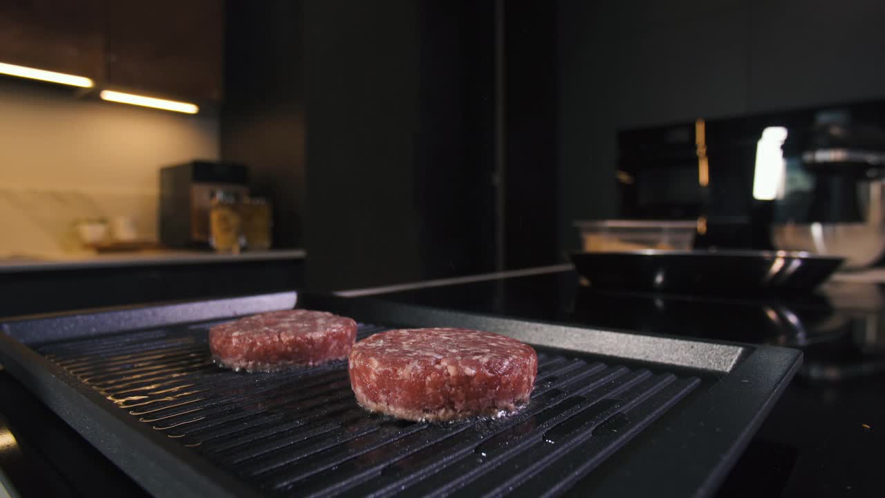 肉汉堡炸肉排在热烤锅上煎。在专业餐厅厨房烹饪食物。准备烧烤晚餐的人。制作美味的汉堡。美味的家现代美食近视频素材