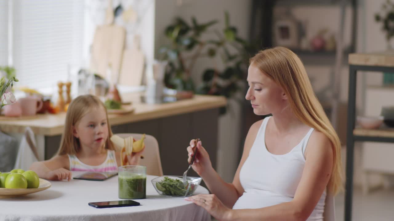 孕妇和小女儿在家吃午饭视频素材