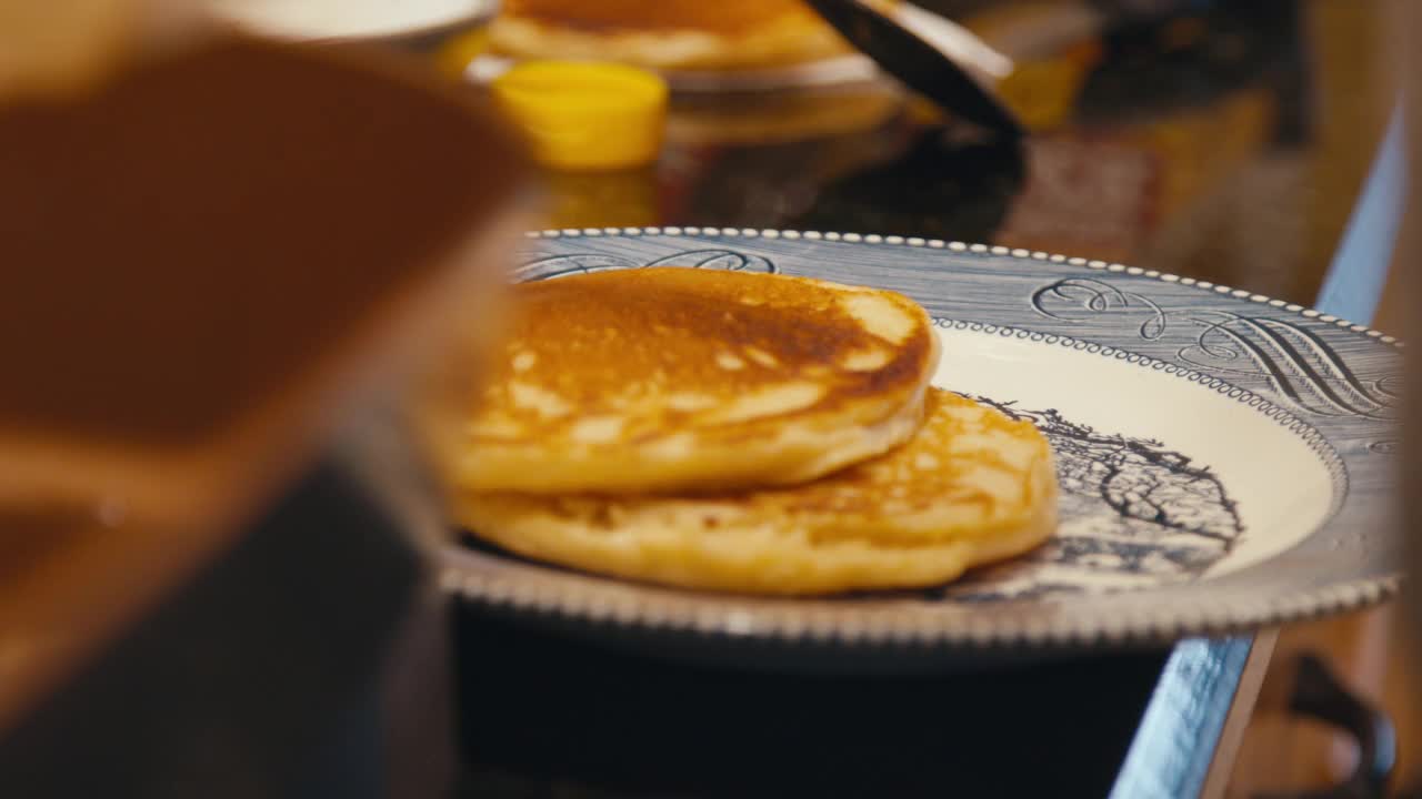 一堆完美烹饪，美味的热煎饼在一个电煎锅后面视频素材