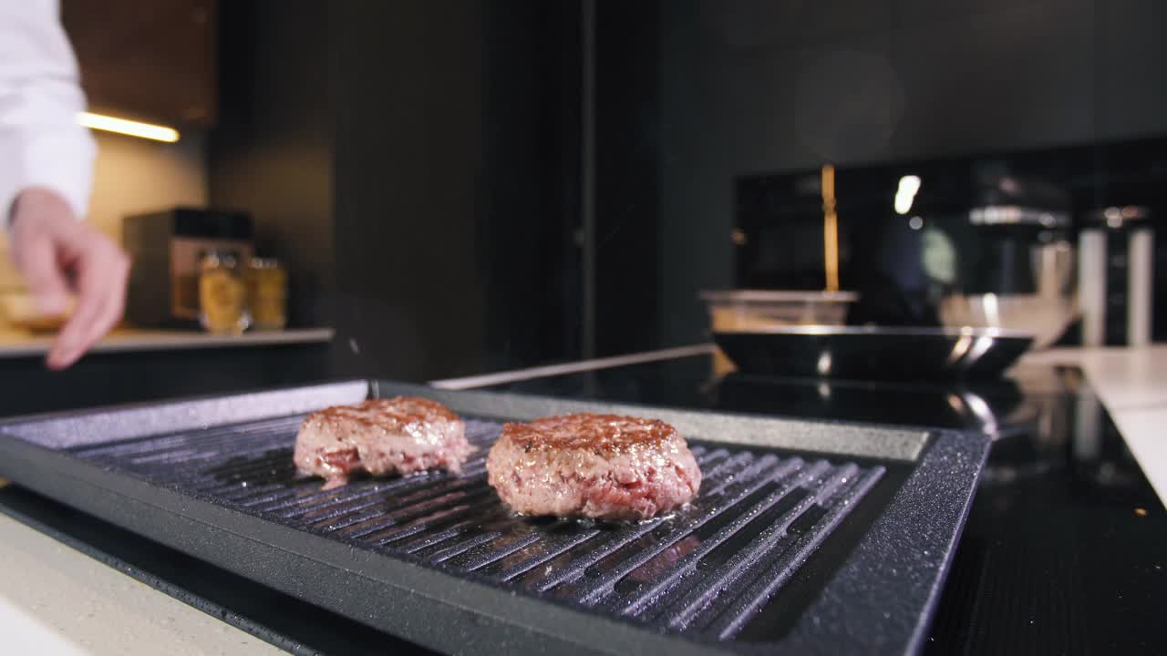 男人在热烤盘上做肉饼。厨师在专业餐厅厨房烹饪食物。准备晚餐的人。制作美味的汉堡。美味的家现代美食近视频素材