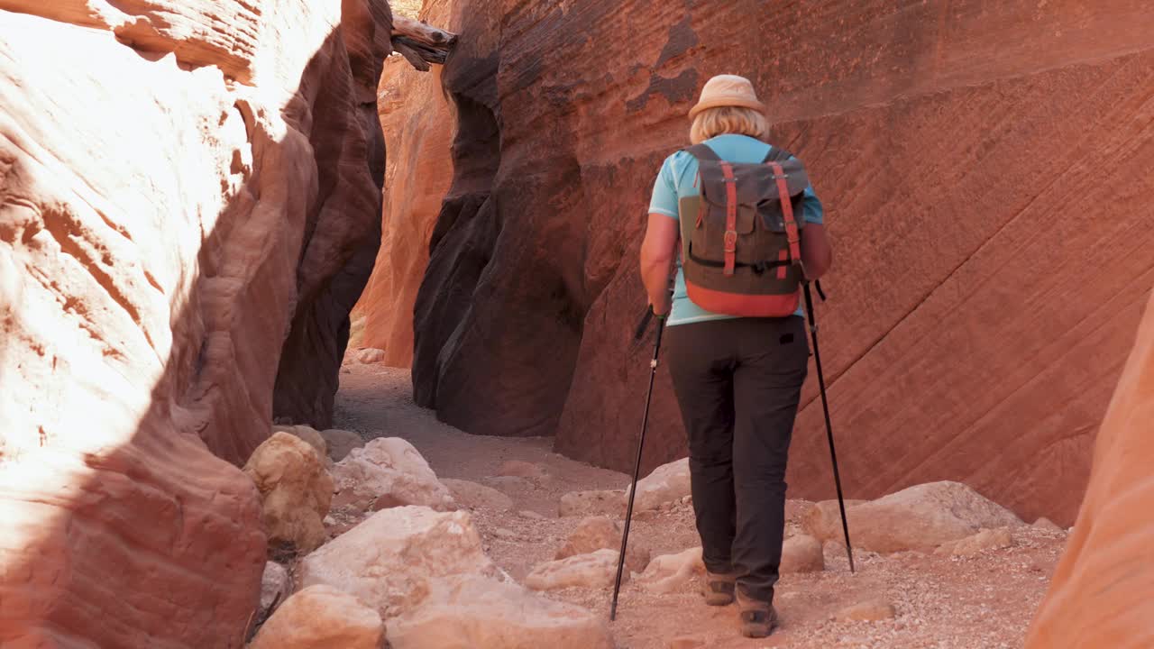 徒步旅行者徒步在山脉和峡谷进入洞穴峡谷与红色的岩石视频素材