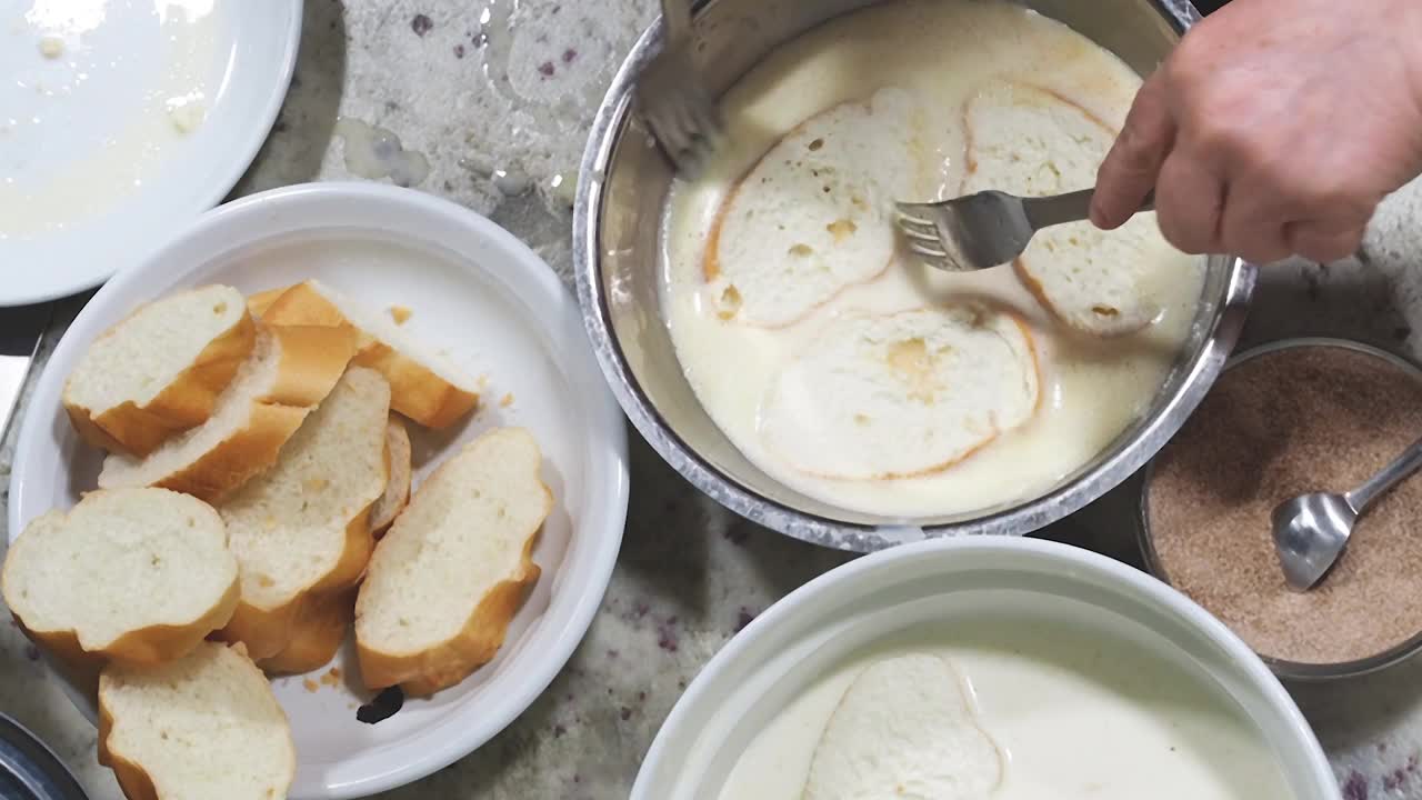 俯视图一个女人准备torrijas(法国吐司)甜点视频下载