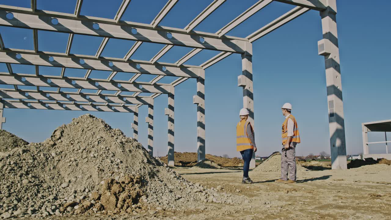 建筑承包商和一名工头评估建筑框架视频素材