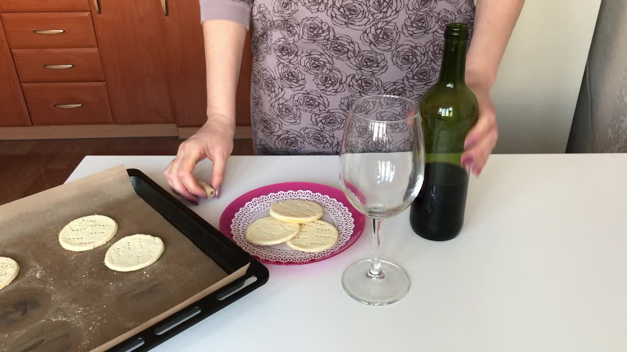 一位妇女将干红葡萄酒倒进玻璃杯。旁边一盘未发酵的玉米粉上。视频素材