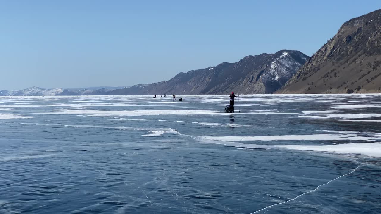 一群游客在结冰的贝加尔湖上溜冰。视频素材