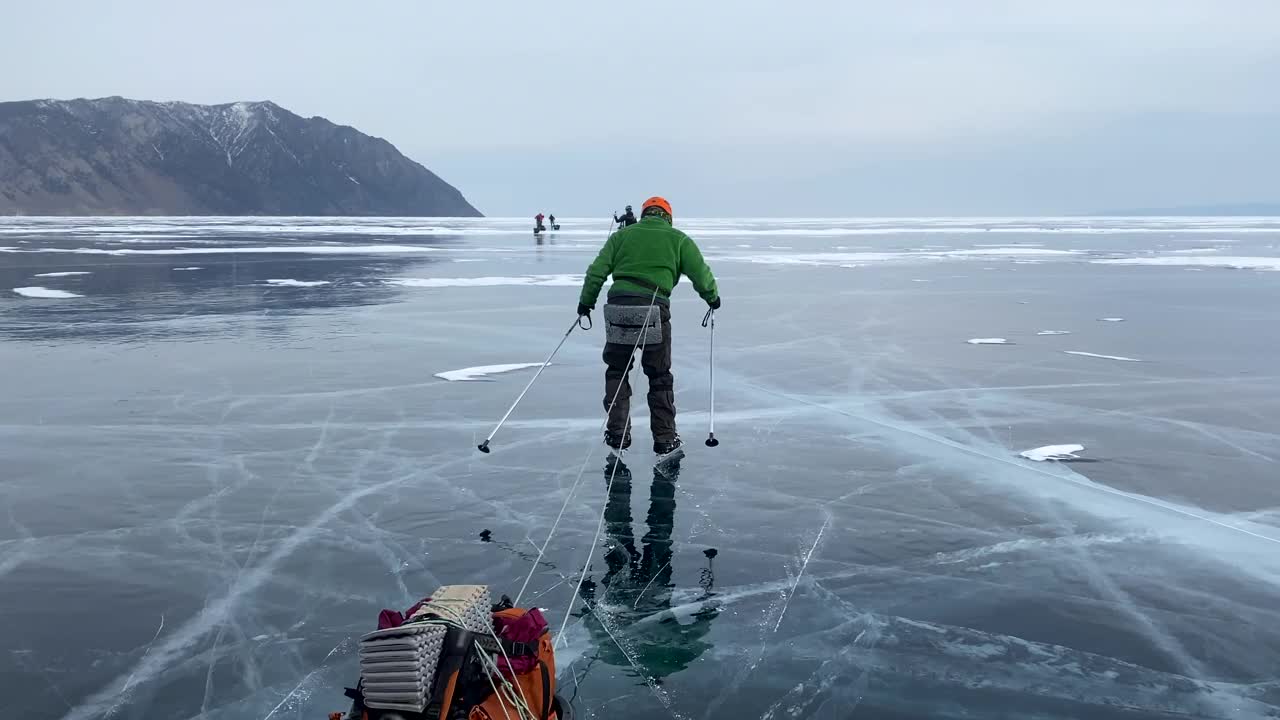 在贝加尔湖上滑冰。一群游客穿着雪橇和冰鞋沿着结冰的贝加尔湖旅行。视频素材