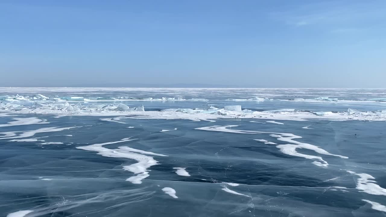 远处一群游客踩着冰鞋旅行的贝加尔湖全景。视频素材