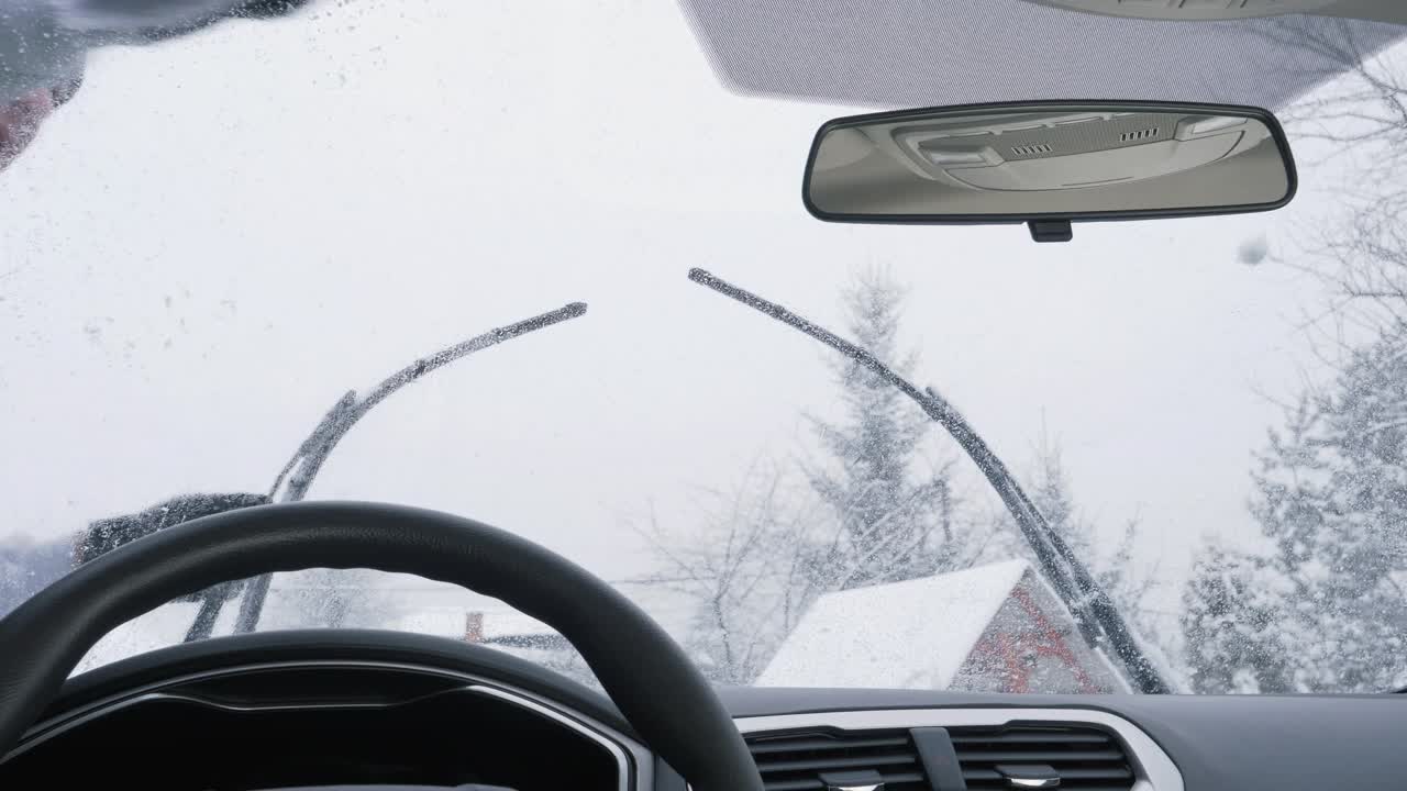 在暴风雪后清洁汽车挡风玻璃视频素材