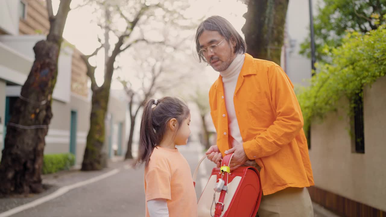 父亲送她小学的小女儿去上学视频素材