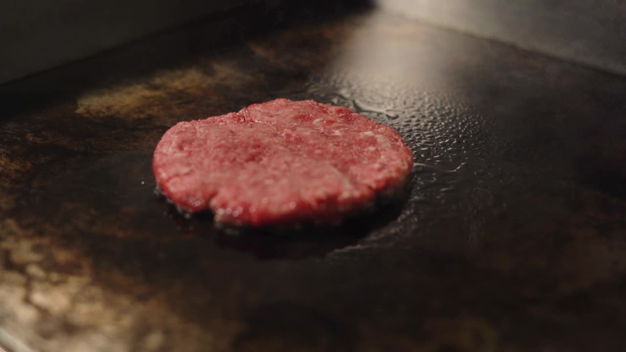 做一个汉堡的牛肉和猪排。肉在厨房里烤。视频素材