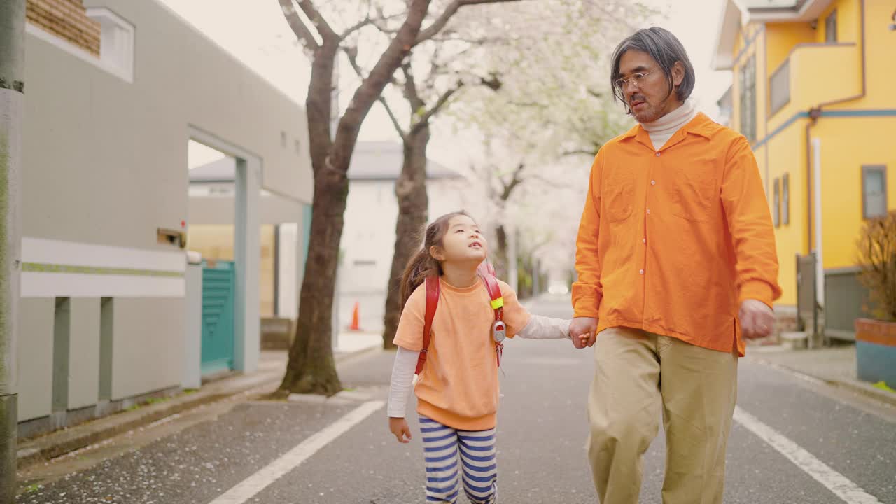 父亲陪着她上小学的小女儿一起去上学视频素材