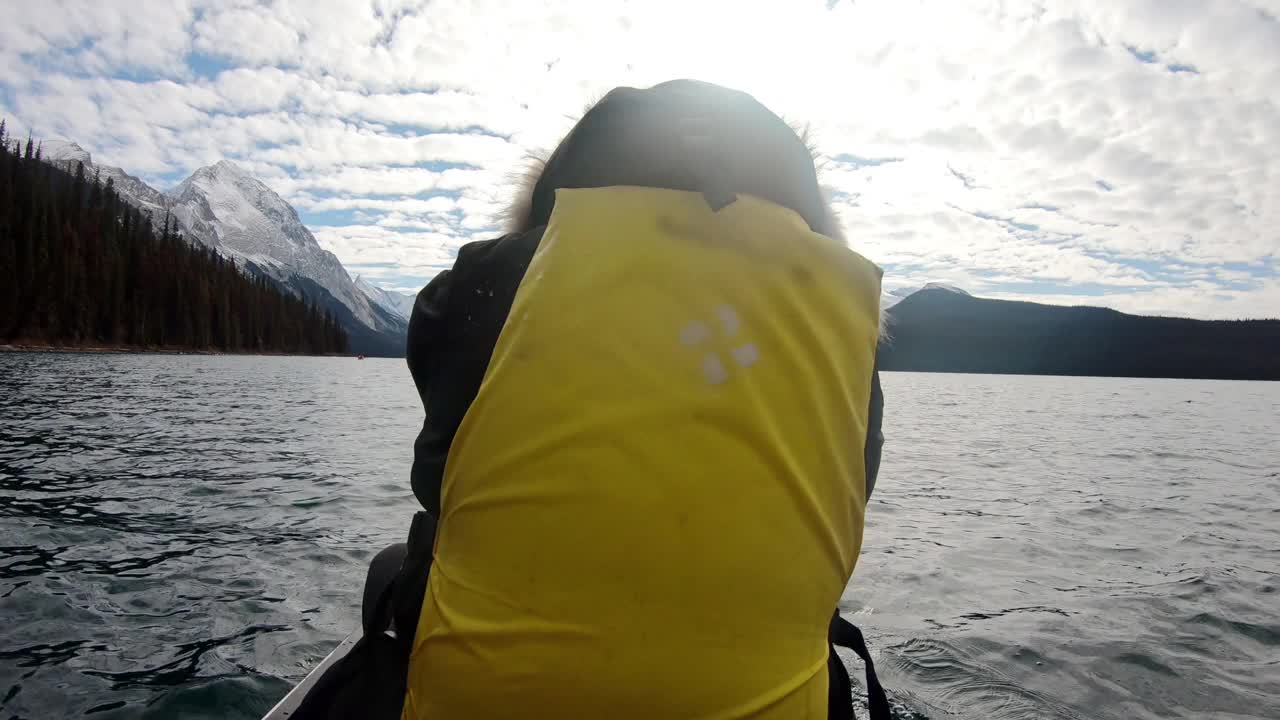 男子旅行者皮划艇在恶性湖进入精灵岛在晴朗的一天在贾斯珀国家公园视频素材