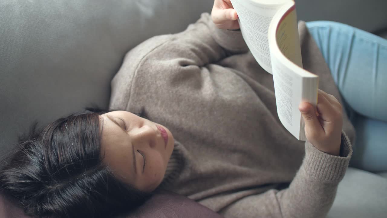 女人在家里放松的时候看书喝咖啡视频素材