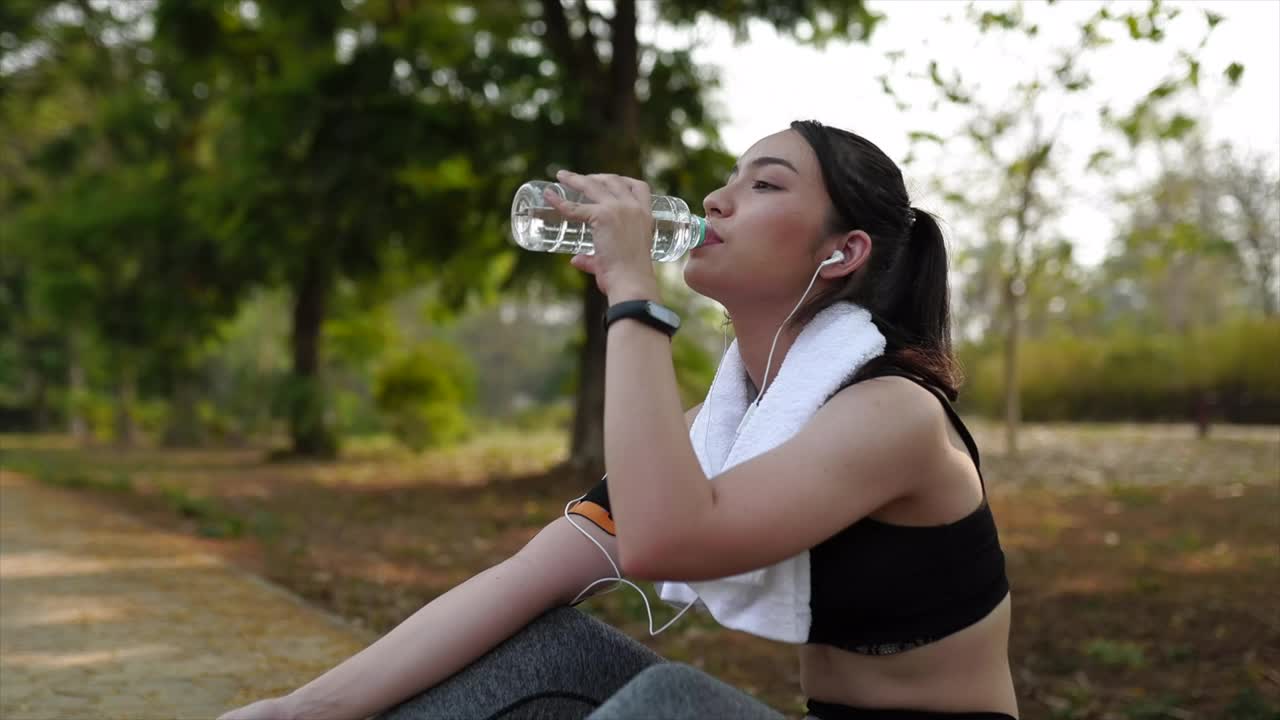 健身女性在锻炼后喝瓶装水。视频素材